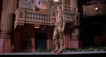 Movie still from “Phantom of the Paradise” (1974), directed by Brian De Palma – A man in a gold outfit on a stage; Wide shot, Low angle