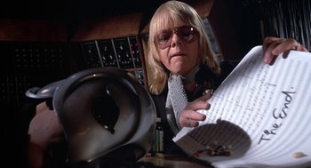 Movie still from “Phantom of the Paradise” (1974), directed by Brian De Palma – A woman holding papers and a phone in front of a microphone; Close Up shot, Low angle