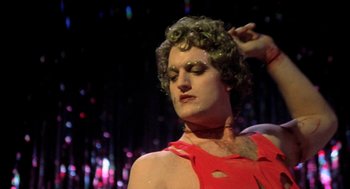 Movie still from “Phantom of the Paradise” (1974), directed by Brian De Palma – A man in a red shirt is posing for a picture; Close Up shot, Low angle