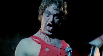 Movie still from “Phantom of the Paradise” (1974), directed by Brian De Palma – A person holding a microphone in a dark room; Close Up shot, Low angle