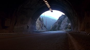 Movie still from “Phantoms” (1998), directed by Joe Chappelle – A road with a mountain in the background; Extreme Wide shot, High angle