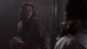 Movie still from “Phantoms” (1998), directed by Joe Chappelle – A woman is standing in front of another woman; Medium shot, Over the shoulder angle