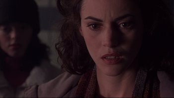 Movie still from “Phantoms” (1998), directed by Joe Chappelle – A woman's face in a dark room; Close Up shot, Over the shoulder angle