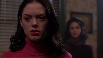 Movie still from “Phantoms” (1998), directed by Joe Chappelle – A woman in a pink sweater is looking at the camera; Close Up shot, Over the shoulder angle