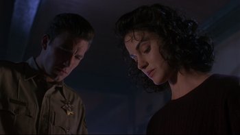 Movie still from “Phantoms” (1998), directed by Joe Chappelle – A man and a woman standing next to each other in the dark; Close Up shot, Low angle
