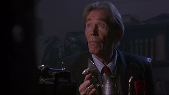 Movie still from “Phantoms” (1998), directed by Joe Chappelle – An older man in a suit holding a cigar; Close Up shot, Low angle