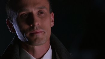 Movie still from “Phantoms” (1998), directed by Joe Chappelle – A person wearing a suit on a cell phone; Close Up shot, Low angle