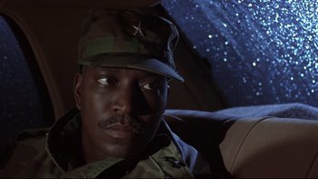 Movie still from “Phantoms” (1998), directed by Joe Chappelle – A man in a military uniform sitting in a car at night; Close Up shot, Low angle