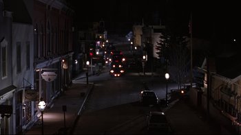 Movie still from “Phantoms” (1998), directed by Joe Chappelle – A city street at night lit by street lights; Extreme Wide shot, High angle