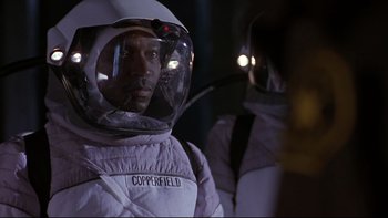 Movie still from “Phantoms” (1998), directed by Joe Chappelle – A man in a spacesuit and a helmet; Medium shot, Low angle