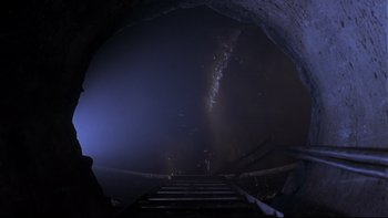 Movie still from “Phantoms” (1998), directed by Joe Chappelle – A view of a cave from the bottom of the stairs; Wide shot, High angle