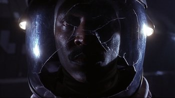 Movie still from “Phantoms” (1998), directed by Joe Chappelle – A man's face through a shattered glass window; Close Up shot, Overhead angle