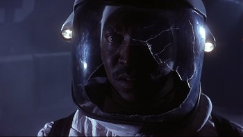 Movie still from “Phantoms” (1998), directed by Joe Chappelle – A man in a spacesuit with a broken helmet; Close Up shot, Low angle