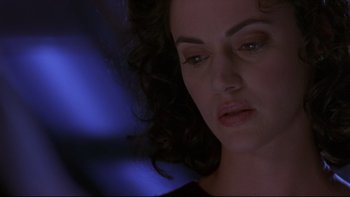 Movie still from “Phantoms” (1998), directed by Joe Chappelle – A woman's face in a dark room; Close Up shot, Low angle