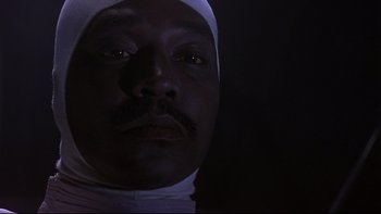 Movie still from “Phantoms” (1998), directed by Joe Chappelle – A person wearing a bandage on his head; Close Up shot, Low angle