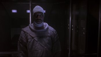 Movie still from “Phantoms” (1998), directed by Joe Chappelle – A man in a space suit standing in a dark room; Medium shot, Low angle