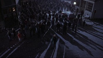 Movie still from “Phantoms” (1998), directed by Joe Chappelle – A group of people standing in the middle of a street; Extreme Wide shot, High angle