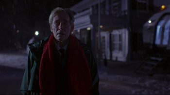 Movie still from “Phantoms” (1998), directed by Joe Chappelle – An older man wearing a red scarf and a black jacket; Medium shot, Low angle