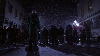 Movie still from “Phantoms” (1998), directed by Joe Chappelle – A group of people standing in the snow at night; Wide shot, Low angle