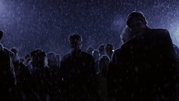 Movie still from “Phantoms” (1998), directed by Joe Chappelle – A group of people standing in the rain; Wide shot, Low angle