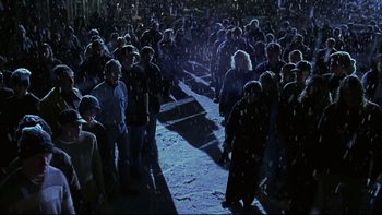 Movie still from “Phantoms” (1998), directed by Joe Chappelle – A group of people standing in the dark; Wide shot, High angle