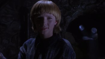 Movie still from “Phantoms” (1998), directed by Joe Chappelle – A young boy with blonde hair is smiling for the camera; Close Up shot, Low angle