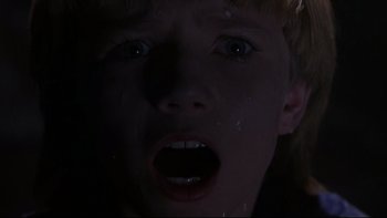 Movie still from “Phantoms” (1998), directed by Joe Chappelle – A young boy is crying in the dark with his mouth open; Close Up shot, Low angle