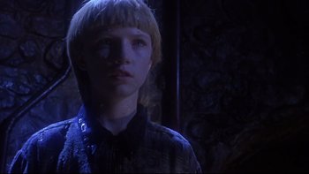 Movie still from “Phantoms” (1998), directed by Joe Chappelle – A young boy with blonde hair and a black shirt; Close Up shot, Low angle