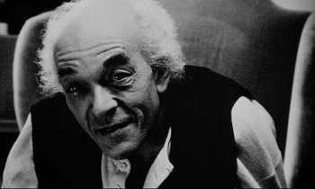 Movie still from “Pi” (1998), directed by Darren Aronofsky – An older man with a beard and a mustache; Close Up shot, Low angle