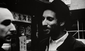 Movie still from “Pi” (1998), directed by Darren Aronofsky – Black and white photograph of a man smiling; Close Up shot, High angle