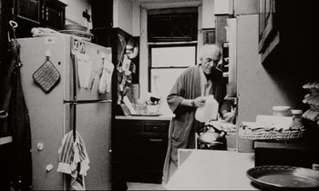 Movie still from “Pi” (1998), directed by Darren Aronofsky – An older man in a robe in a kitchen; Medium shot, Low angle