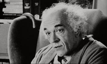 Movie still from “Pi” (1998), directed by Darren Aronofsky – An older man with a white beard is sitting on a bus; Close Up shot, High angle