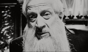 Movie still from “Pi” (1998), directed by Darren Aronofsky – An old man with a long white beard; Close Up shot, High angle