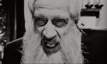 Movie still from “Pi” (1998), directed by Darren Aronofsky – An old man with a long white beard; Extreme Close Up shot, Overhead angle