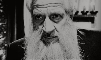 Movie still from “Pi” (1998), directed by Darren Aronofsky – An old man with a long white beard; Close Up shot, High angle