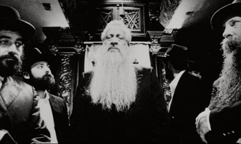 Movie still from “Pi” (1998), directed by Darren Aronofsky – A man with long white beard standing in front of a mirror; Close Up shot, Low angle