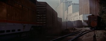Movie still from “Picnic” (1955), directed by Joshua Logan – A train is traveling down the train tracks; Wide shot, Low angle