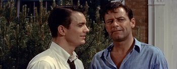 Movie still from “Picnic” (1955), directed by Joshua Logan – Two men standing next to each other in front of a tree; Close Up shot, Over the shoulder angle