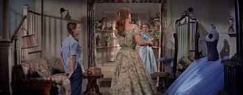 Movie still from “Picnic” (1955), directed by Joshua Logan – A woman in a green dress standing in front of a mirror; Medium shot, Low angle