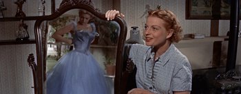 Movie still from “Picnic” (1955), directed by Joshua Logan – A woman sitting in front of a mirror in front of a dress; Medium shot, Low angle