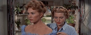 Movie still from “Picnic” (1955), directed by Joshua Logan – Two women are standing next to each other; Close Up shot, Over the shoulder angle