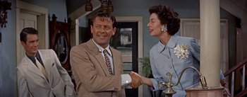 Movie still from “Picnic” (1955), directed by Joshua Logan – A man and a woman shaking hands in a room; Medium shot, Over the shoulder angle
