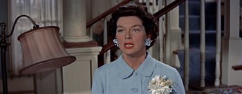 Movie still from “Picnic” (1955), directed by Joshua Logan – An older woman wearing a blue dress and a flower in her hair; Close Up shot, Low angle