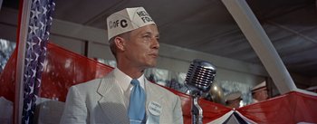 Movie still from “Picnic” (1955), directed by Joshua Logan – A man wearing a white hat and a microphone; Medium shot, Low angle