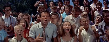 Movie still from “Picnic” (1955), directed by Joshua Logan – A group of people that are standing in the grass; Medium shot, Low angle