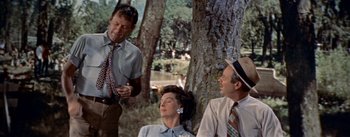Movie still from “Picnic” (1955), directed by Joshua Logan – A group of people sitting next to a tree; Medium shot, Over the shoulder angle
