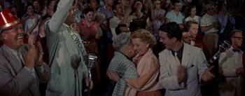 Movie still from “Picnic” (1955), directed by Joshua Logan – Two women embracing each other in front of an audience; Medium shot, Over the shoulder angle