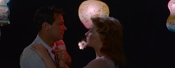 Movie still from “Picnic” (1955), directed by Joshua Logan – A man and a woman standing next to each other in front of a paper lantern; Close Up shot, Low angle