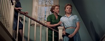 Movie still from “Picnic” (1955), directed by Joshua Logan – Two women standing next to each other near a railing; Medium shot, Low angle