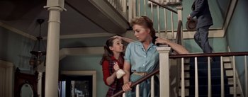 Movie still from “Picnic” (1955), directed by Joshua Logan – Two young women standing at the bottom of a staircase; Medium shot, Low angle